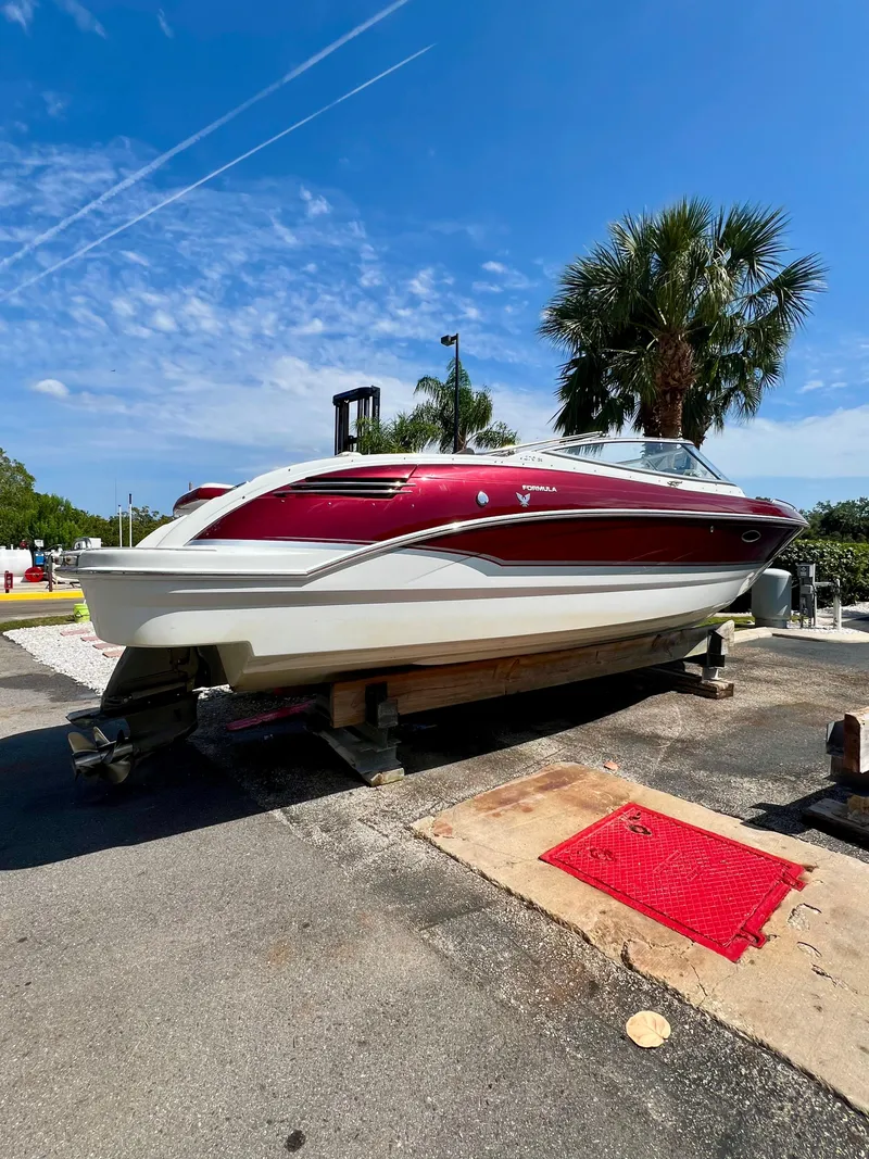 Slide: The Image of 2011 Formula 270 Bowrider boat on a trailer under a clear blue sky. - 16