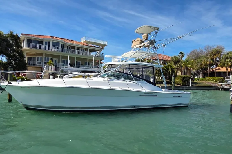 The Image of 2004 Riviera 4000 Offshore yacht docked near waterfront homes. - 0