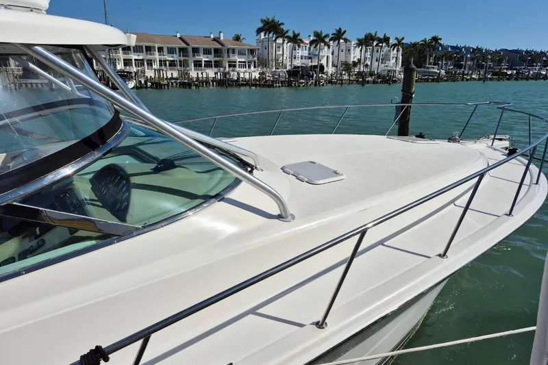 Slide: The Image of 2004 Riviera 4000 Offshore yacht docked in a marina with waterfront buildings. - 3