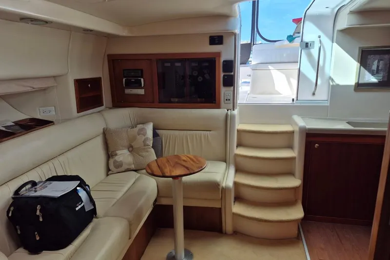 Slide: The Image of Interior of 2004 Riviera 4000 Offshore yacht with beige seating and wooden accents. - 57