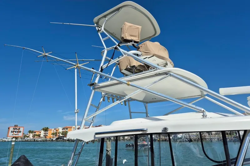 Slide: The Image of 2004 Riviera 4000 Offshore boat with tower, docked in a marina under clear blue skies. - 4