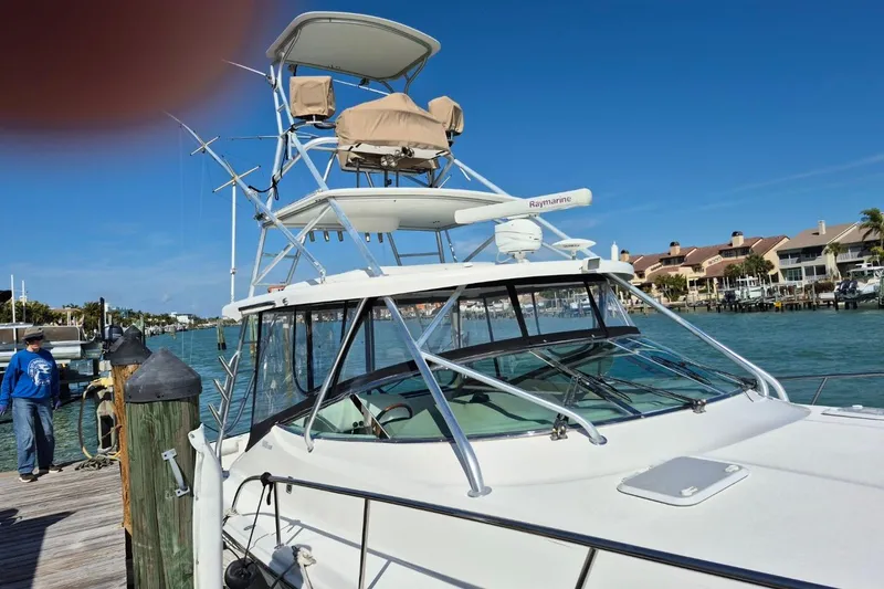 Slide: The Image of 2004 Riviera 4000 Offshore yacht docked at marina with clear blue sky. - 6