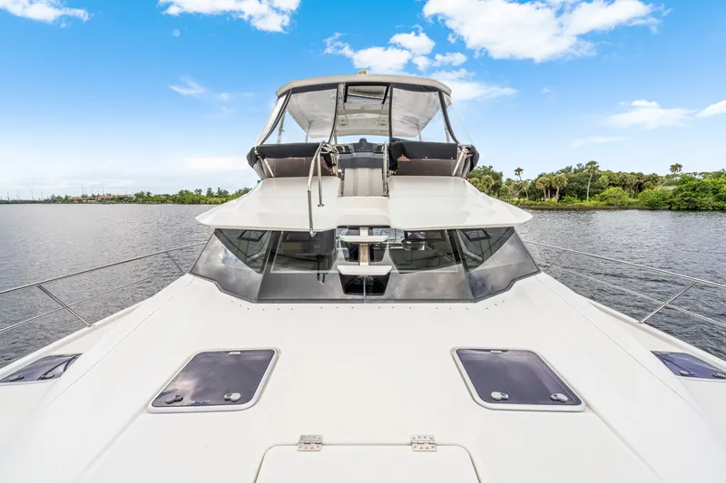 Slide: The Image of 2019 Aquila 44 Yacht on serene water, showcasing sleek design and spacious deck. - 16