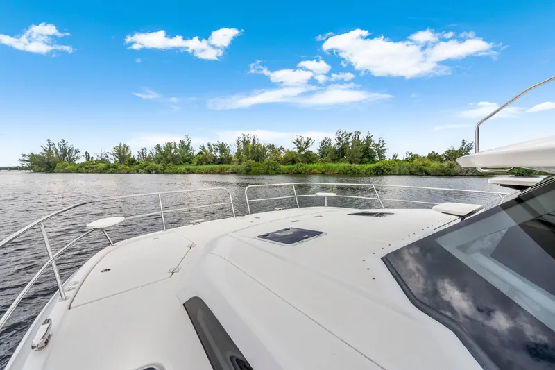Slide: The Image of Aquila 44 Yacht 2019 cruising on a serene river under a clear blue sky. - 18