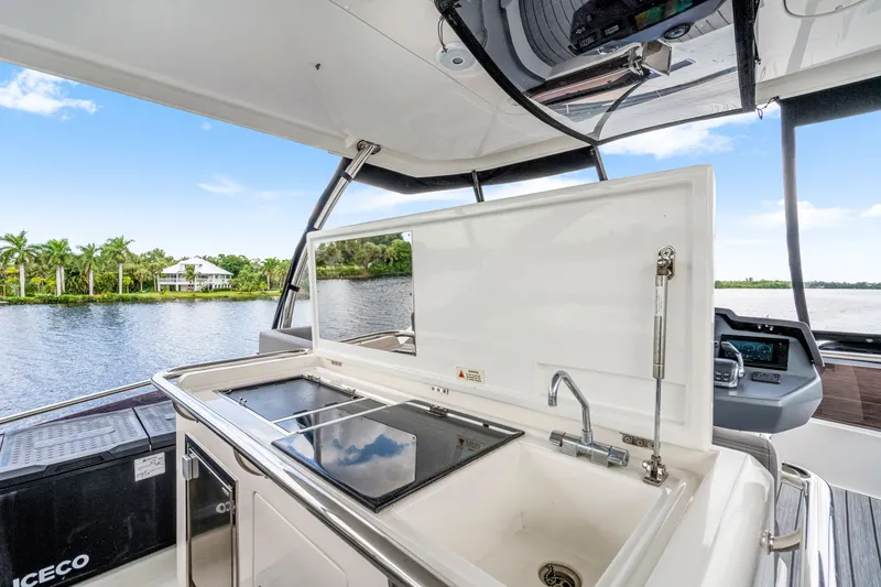 Slide: The Image of Outdoor kitchen on 2019 Aquila 44 Yacht with sink and cooktop, overlooking serene waterway. - 34