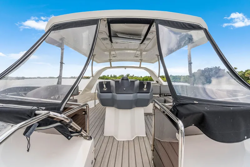 Slide: The Image of 2019 Aquila 44 Yacht helm with clear canopy, sleek design, and scenic water view. - 28