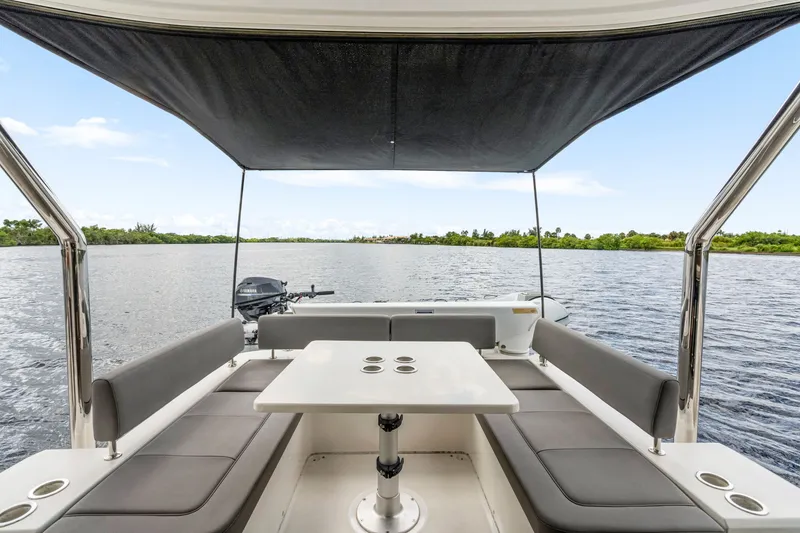 Slide: The Image of Aquila 44 Yacht 2019 interior with seating and table, overlooking serene water. - 22