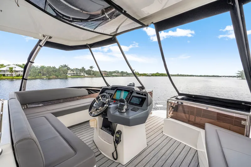 Slide: The Image of Luxurious 2019 Aquila 44 Yacht interior with modern helm, overlooking serene waterfront view. - 30