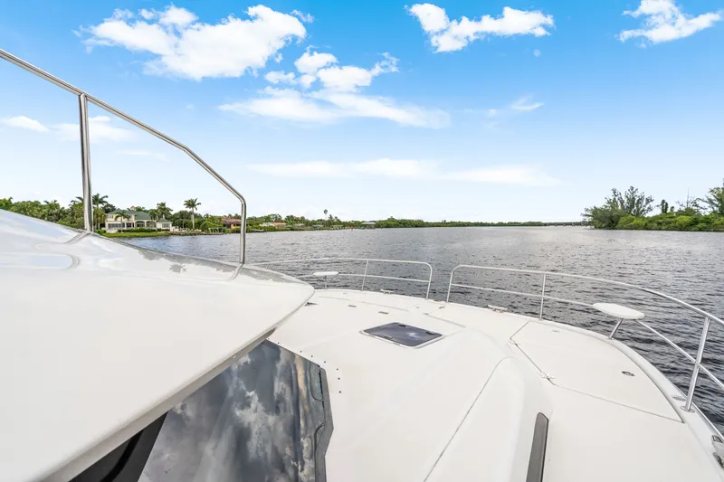 Slide: The Image of 2019 Aquila 44 Yacht cruising on a serene river under a clear blue sky. - 19