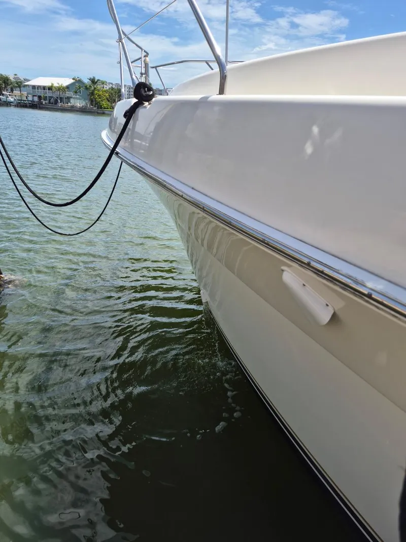 Slide: The Image of 2002 Silverton 38 Convertible yacht docked on calm water under a clear sky. - 5