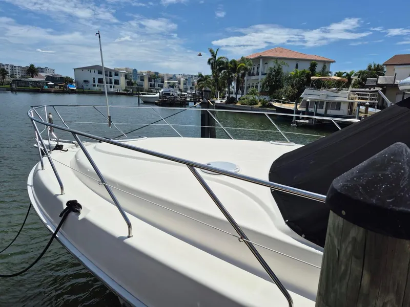 Slide: The Image of 2002 Silverton 38 Convertible yacht docked in a scenic marina setting. - 4