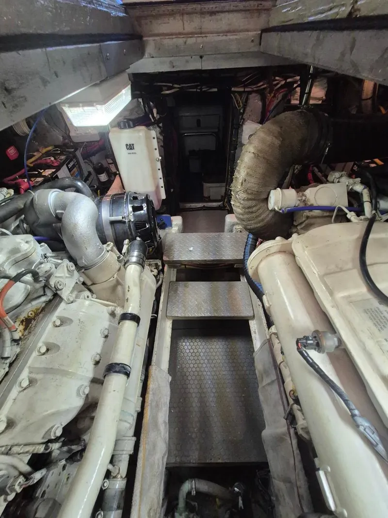 Slide: The Image of Engine room of a 2002 Silverton 38 Convertible boat, featuring dual engines and mechanical components. - 46