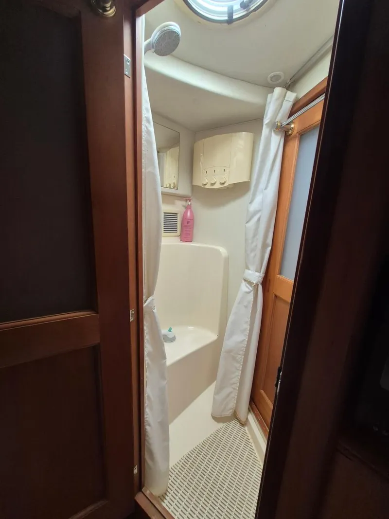 Slide: The Image of Shower area in 2002 Silverton 38 Convertible boat with curtain and wooden door. - 32