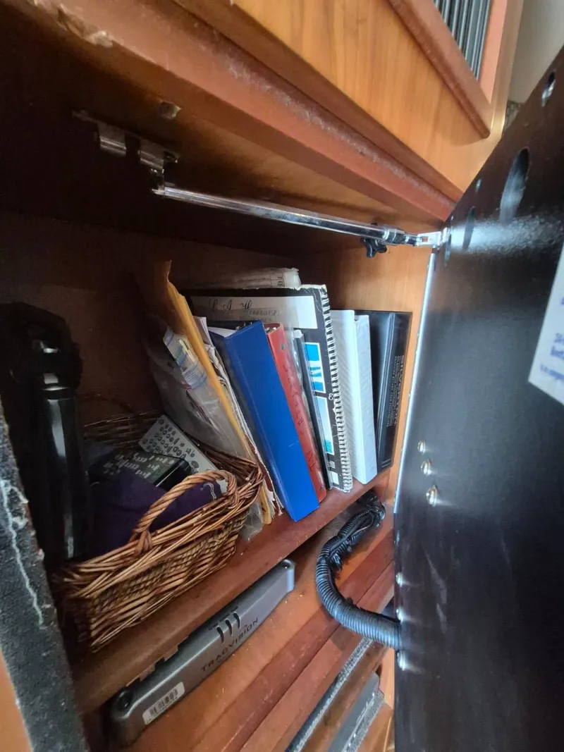 Slide: The Image of Cabinet interior with books and basket on a 2002 Silverton 38 Convertible boat. - 27