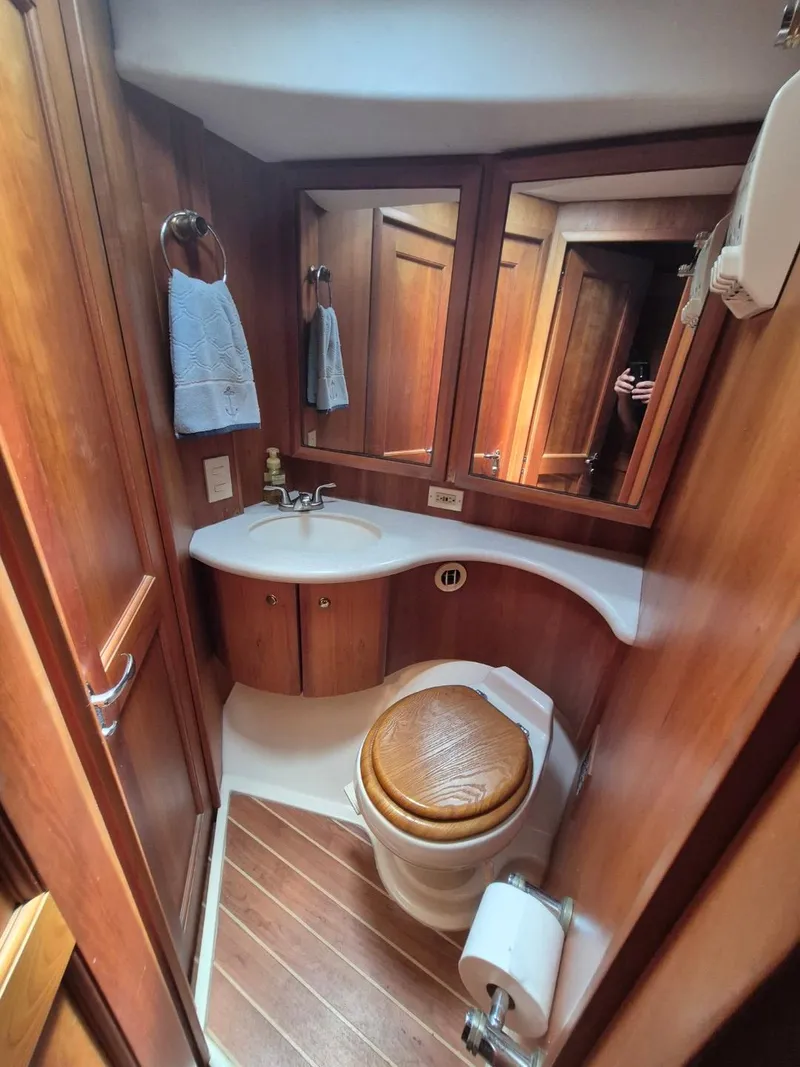 Slide: The Image of 2002 Silverton 38 Convertible yacht bathroom with wooden cabinetry and compact design. - 30