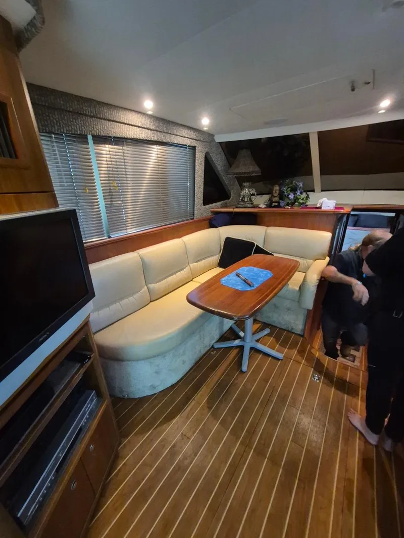 Slide: The Image of Interior of 2002 Silverton 38 Convertible yacht with cozy seating and wooden flooring. - 49