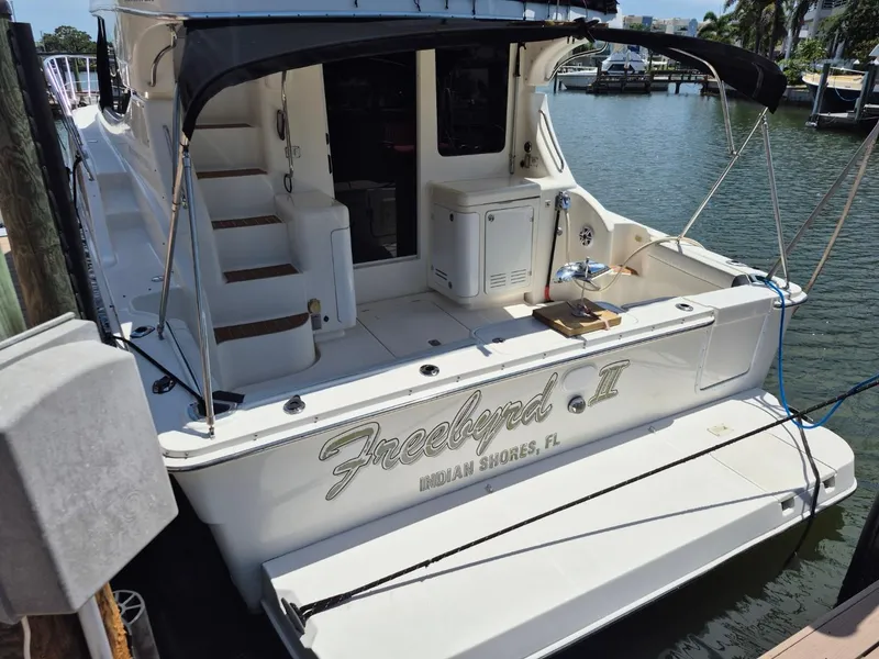 Slide: The Image of 2002 Silverton 38 Convertible yacht docked, featuring "Freebyrd II" name, Indian Shores, FL. - 2