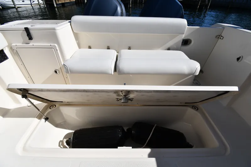 Slide: The Image of 2004 Pursuit 2670 Denali LS boat with open storage compartment and cushioned seating. - 22
