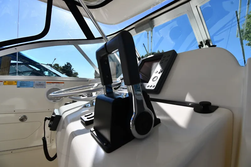 Slide: The Image of 2004 Pursuit 2670 Denali LS boat cockpit with steering controls and navigation system. - 11
