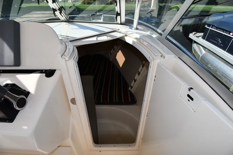 Slide: The Image of 2004 Pursuit 2670 Denali LS cabin entrance with striped interior cushions. - 27