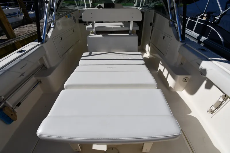 Slide: The Image of 2004 Pursuit 2670 Denali LS boat interior with white cushioned seating. - 25
