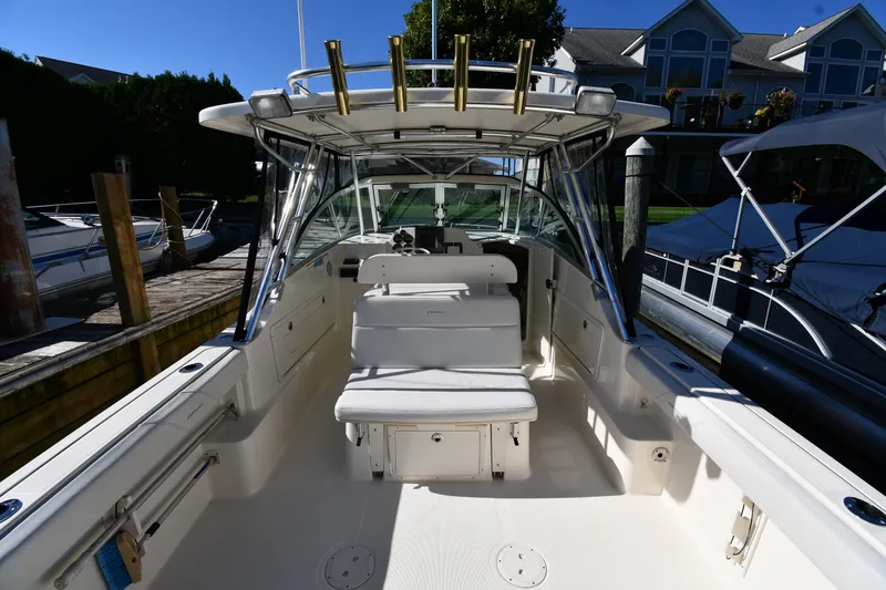 Slide: The Image of 2004 Pursuit 2670 Denali LS boat docked, showcasing spacious seating and sleek design. - 7
