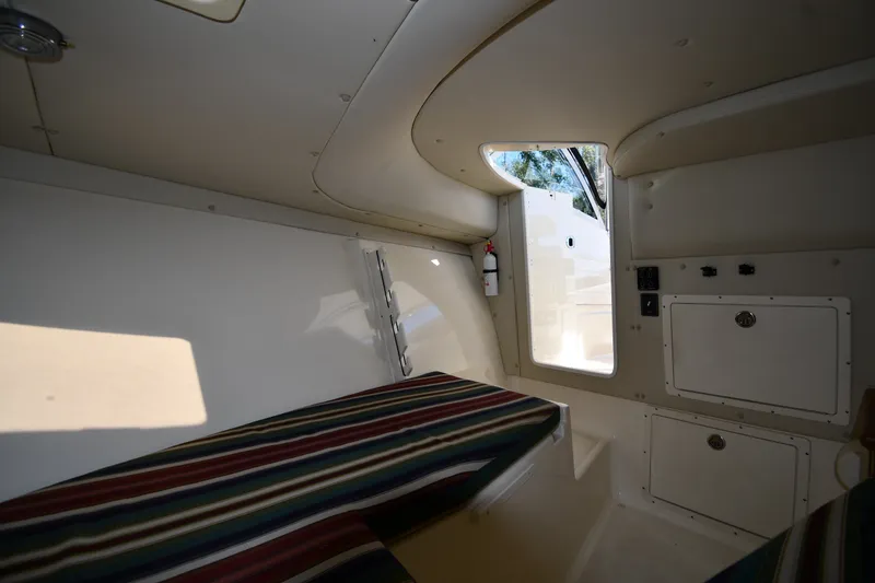Slide: The Image of Interior cabin of 2004 Pursuit 2670 Denali LS boat with striped seating and storage compartments. - 32