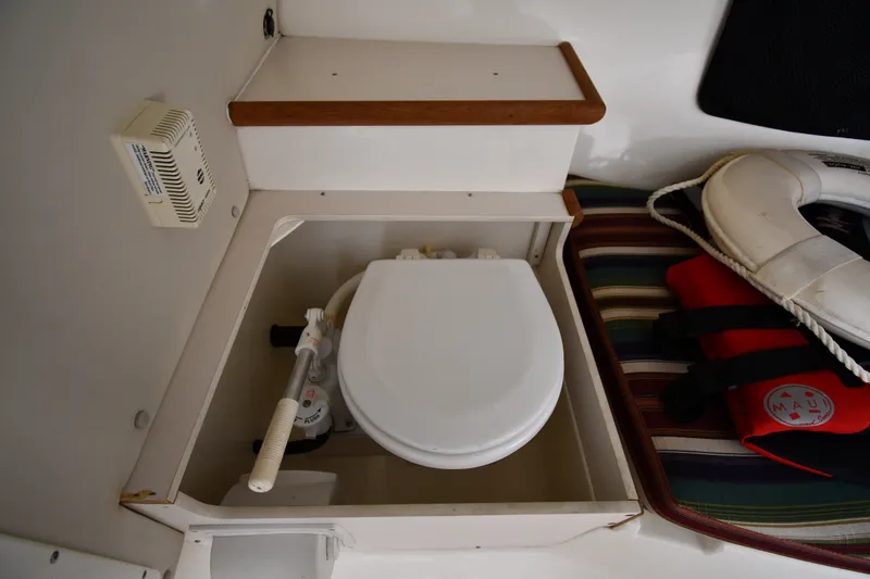 Slide: The Image of 2004 Pursuit 2670 Denali LS boat interior with toilet, life preserver, and life jacket. - 33