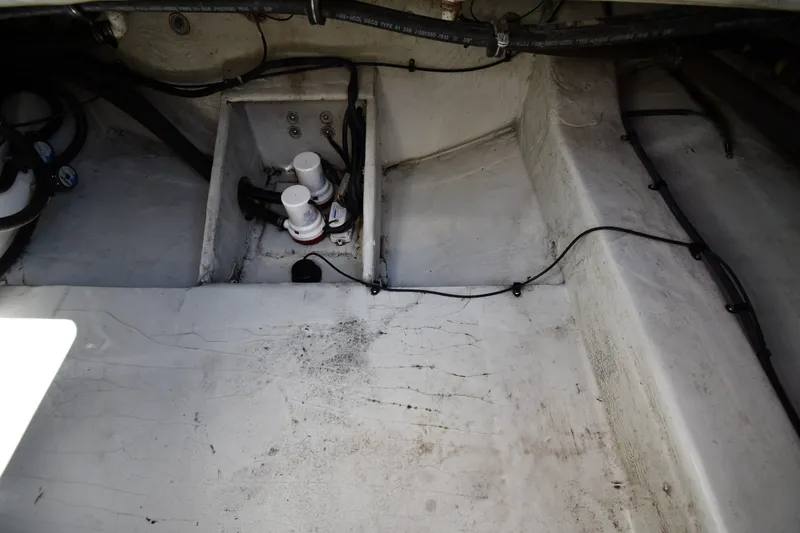 Slide: The Image of 2004 Pursuit 2670 Denali LS boat interior showing bilge area with pumps and wiring. - 38
