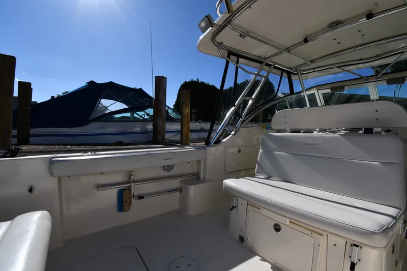 Slide: The Image of 2004 Pursuit 2670 Denali LS boat interior with seating and clear blue sky. - 17