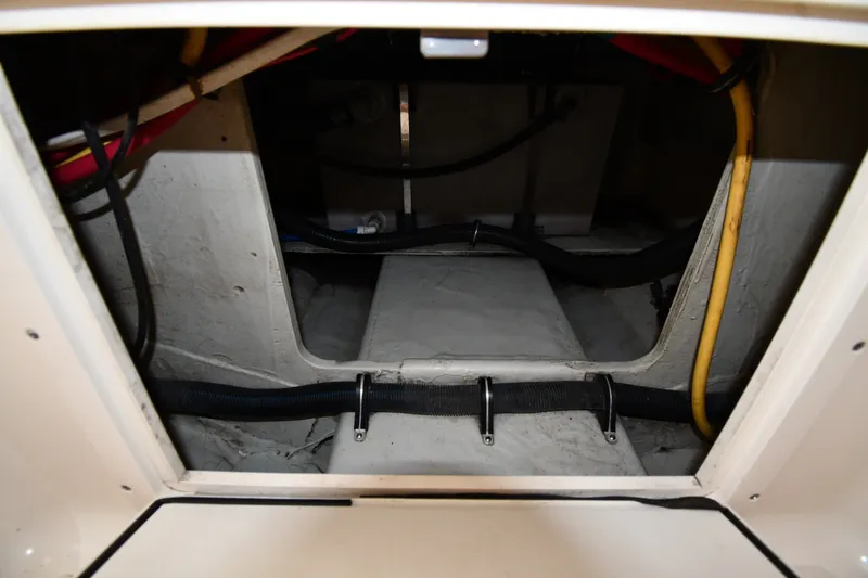 Slide: The Image of 2004 Pursuit 2670 Denali LS boat interior compartment with visible wiring and hoses. - 35