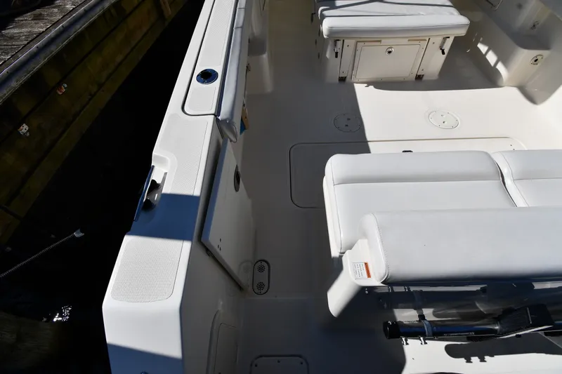 Slide: The Image of 2004 Pursuit 2670 Denali LS boat interior with white seating and storage compartments. - 19