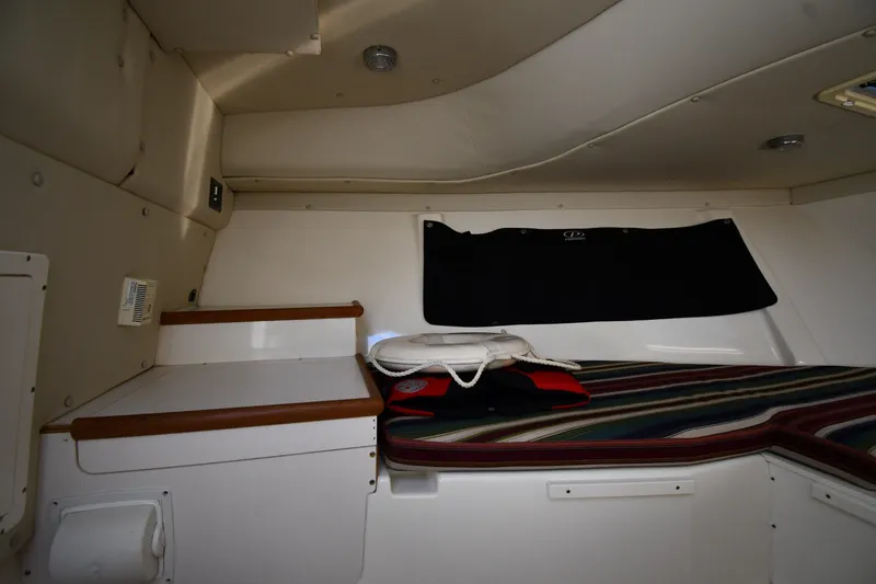 Slide: The Image of Interior cabin of 2004 Pursuit 2670 Denali LS boat with striped cushions and storage. - 30