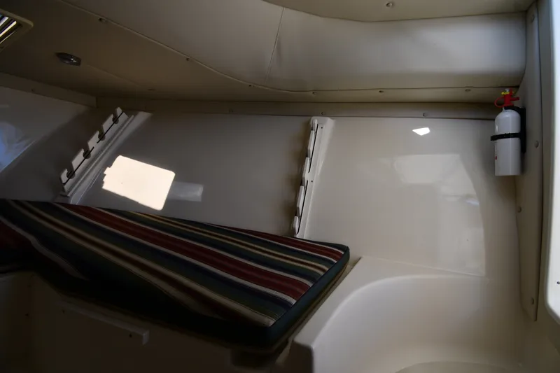 Slide: The Image of Interior cabin of 2004 Pursuit 2670 Denali LS boat with striped cushion and fire extinguisher. - 29
