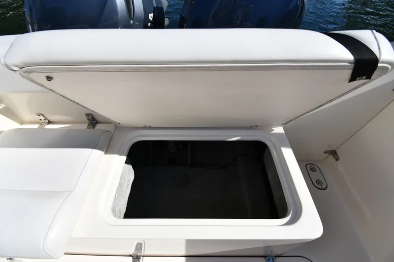 Slide: The Image of Open storage compartment on a 2004 Pursuit 2670 Denali LS boat, with cushioned seating. - 37