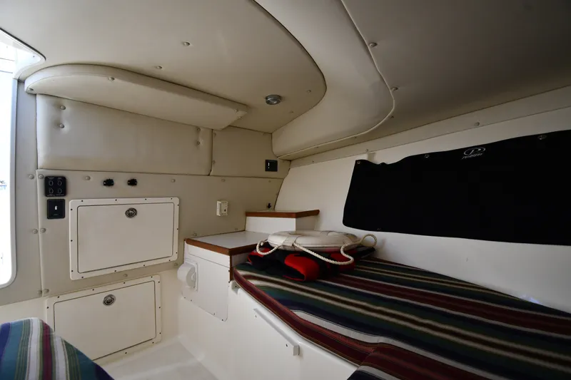 Slide: The Image of Interior cabin of 2004 Pursuit 2670 Denali LS boat with striped seating and storage compartments. - 31