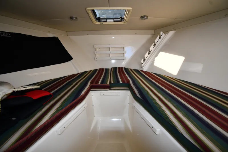 Slide: The Image of Interior cabin of 2004 Pursuit 2670 Denali LS with striped cushions and overhead hatch. - 28