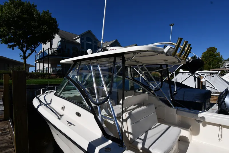 Slide: The Image of 2004 Pursuit 2670 Denali LS boat docked near waterfront homes. - 3