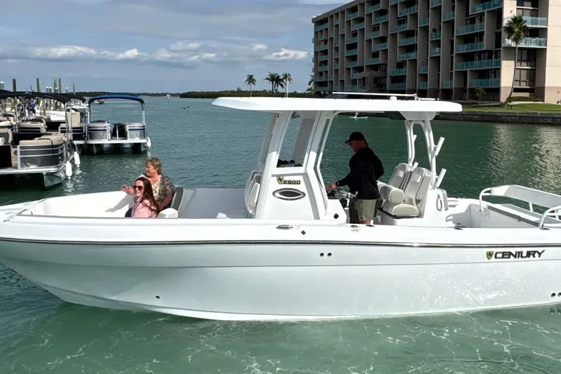 Slide: The Image of 2022 Century 2900 Center Console boat cruising near a marina with passengers onboard. - 0