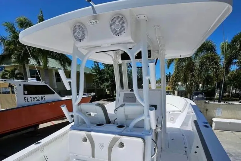 Slide: The Image of 2022 Century 2900 Center Console boat with T-top, docked near palm trees. - 7