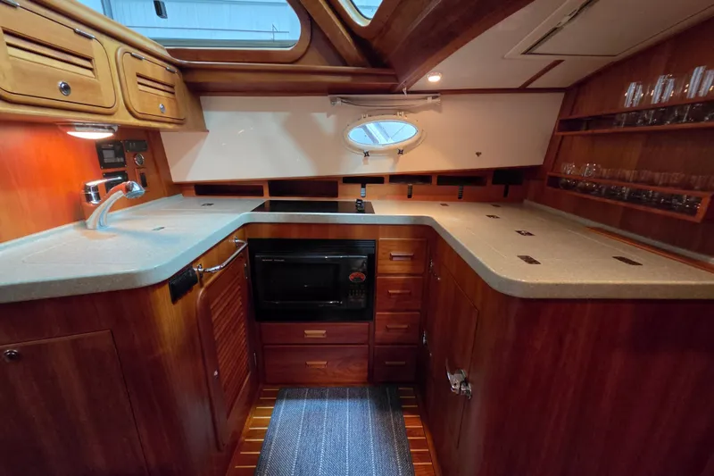 Slide: The Image of Luxurious 2009 Hinckley Talaria 44 yacht interior with elegant wooden cabinetry and modern kitchen amenities. - 11