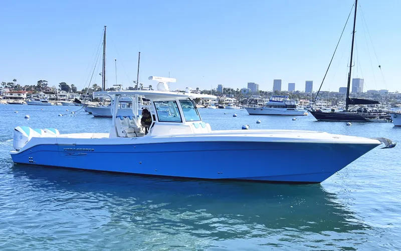 Slide: The Image of 2018 HCB 39 Speciale boat in blue, docked in a marina with city skyline. - 0
