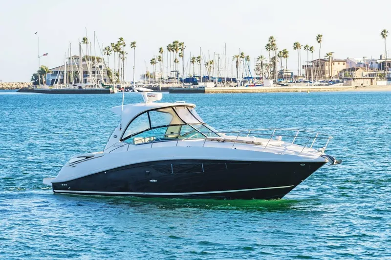 Slide: The Image of 2016 Sea Ray 370 Express Cruiser on calm waters near marina. - 1