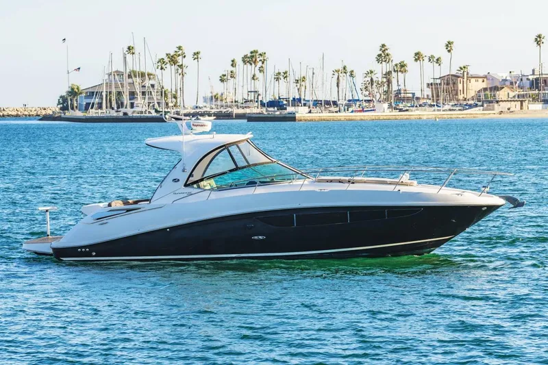 Slide: The Image of 2016 Sea Ray 370 Express Cruiser yacht on calm water near marina. - 0
