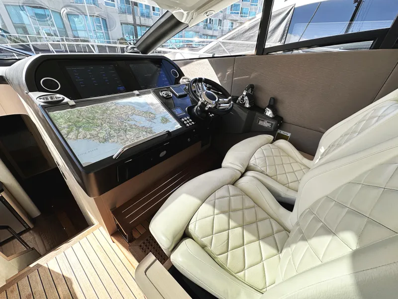 Slide: The Image of Luxurious 2015 Sunseeker Predator 57 yacht cockpit with plush seating and advanced navigation controls. - 19