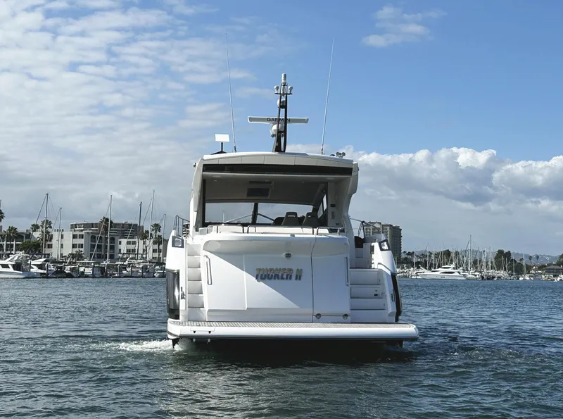 Slide: The Image of Sunseeker Predator 57 yacht cruising in a marina, 2015 model, under a partly cloudy sky. - 9