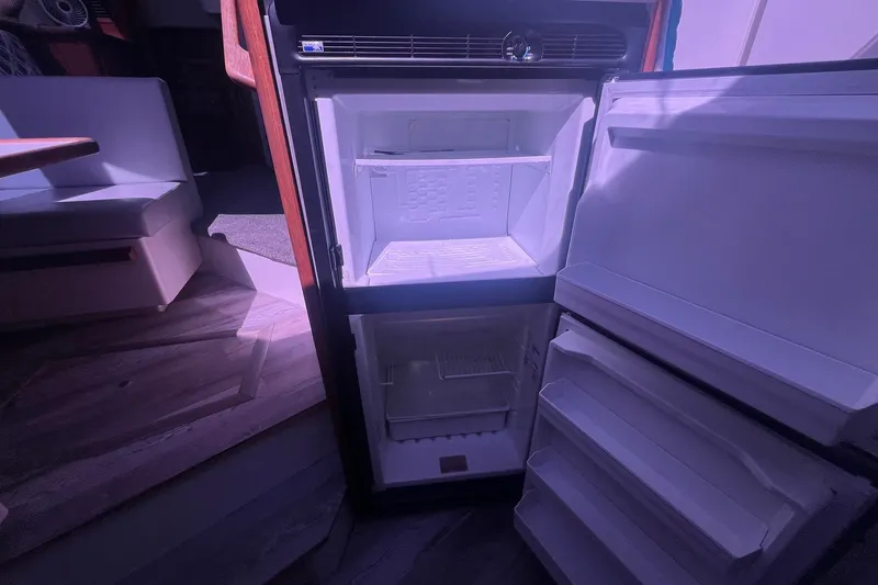Slide: The Image of Open refrigerator inside 1992 Carver 33 Aft Cabin Motor Yacht, showcasing interior storage space. - 26