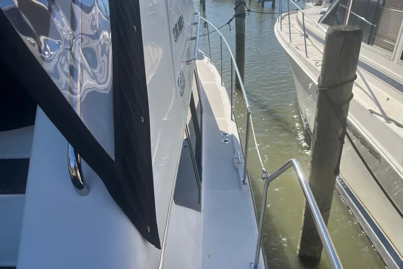 Slide: The Image of 1992 Carver 33 Aft Cabin Motor Yacht docked, side view with railing and water. - 15