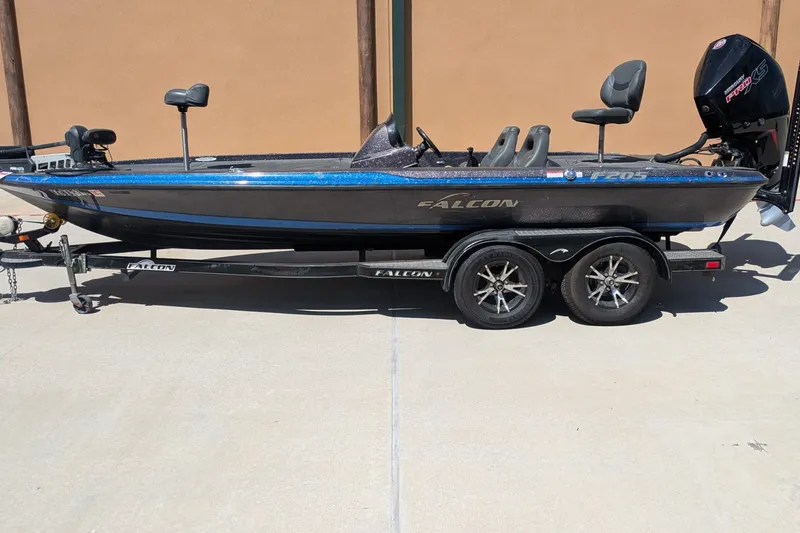 Slide: The Image of 2018 Falcon F205 fishing boat on trailer, featuring dual seats and powerful outboard motor. - 1