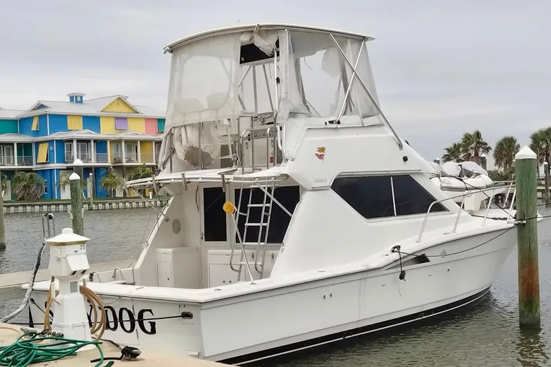 Slide: The Image of 1995 Hatteras 39 Convertible yacht docked near colorful waterfront buildings. - 2